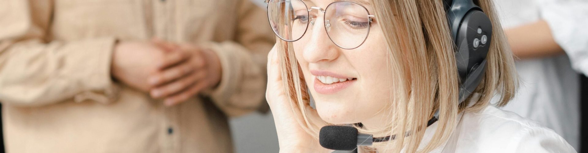 Professional woman providing customer support with a headset in an office setting.